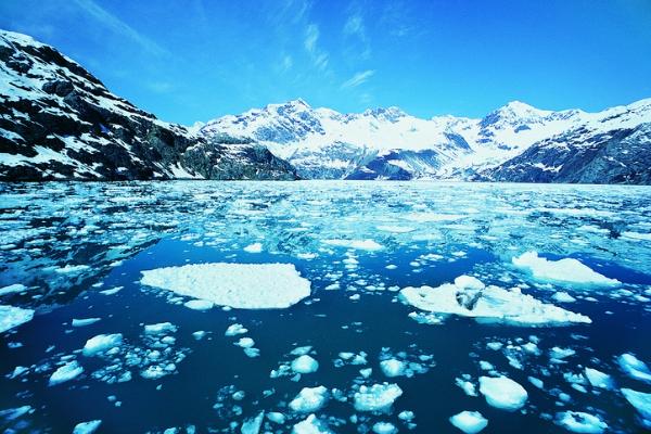 Stunning glacial landscape with blue water, ice floes, and snow-capped mountains, representing a cruise destination gift.