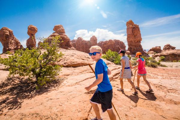 Family hiking through a national park during a summer getaway.