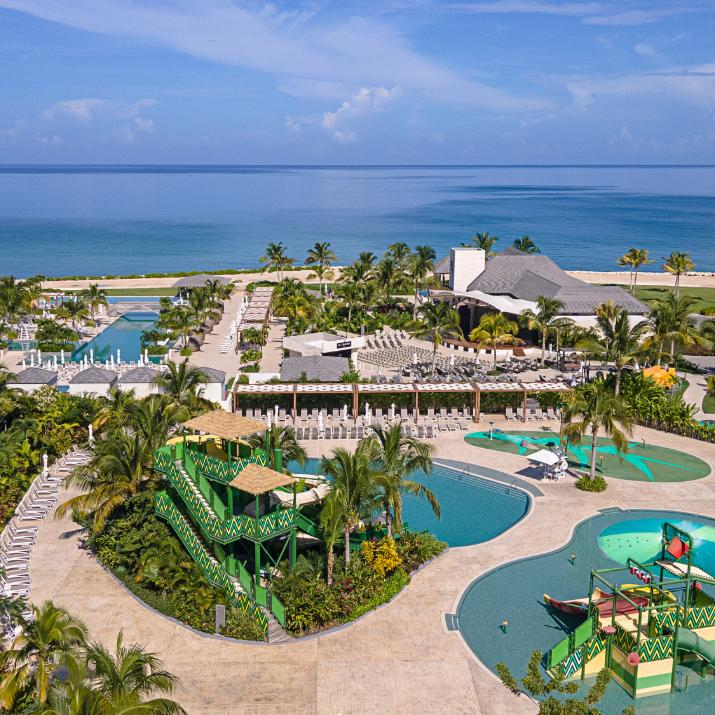 Family-friendly pools and colorful water slides at Princess Grand Jamaica overlooking the Caribbean Sea.