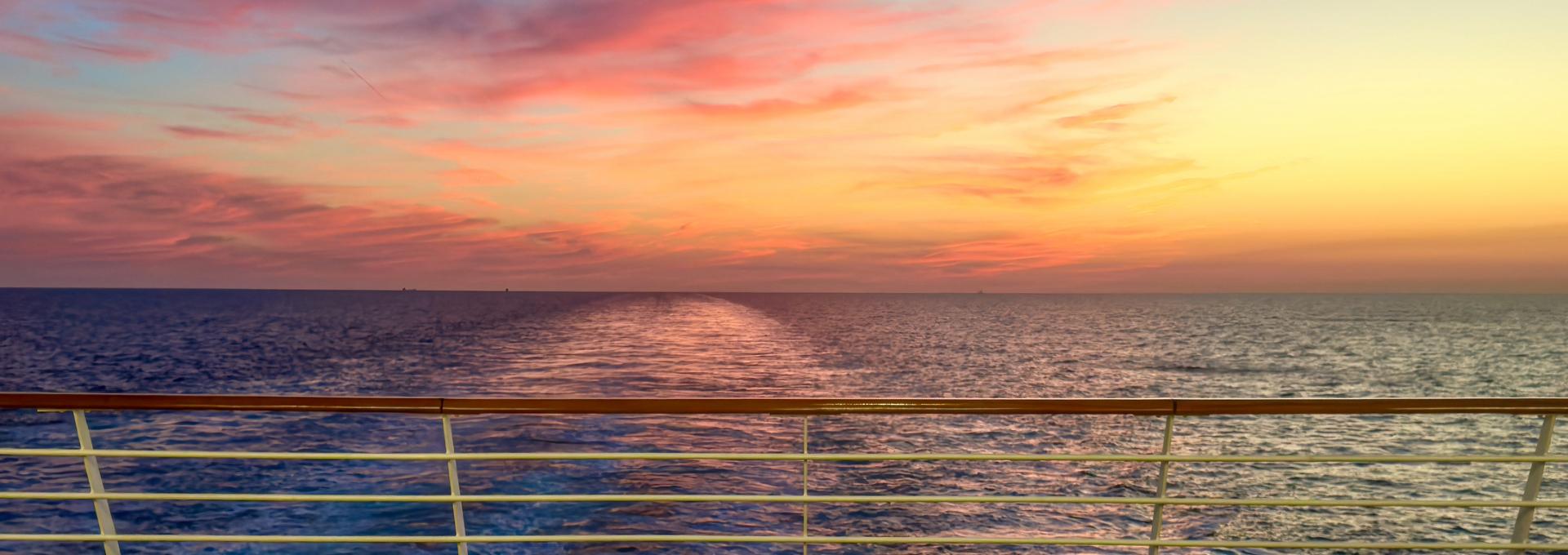 Colorful sunset over the ocean viewed from the deck of a cruise ship