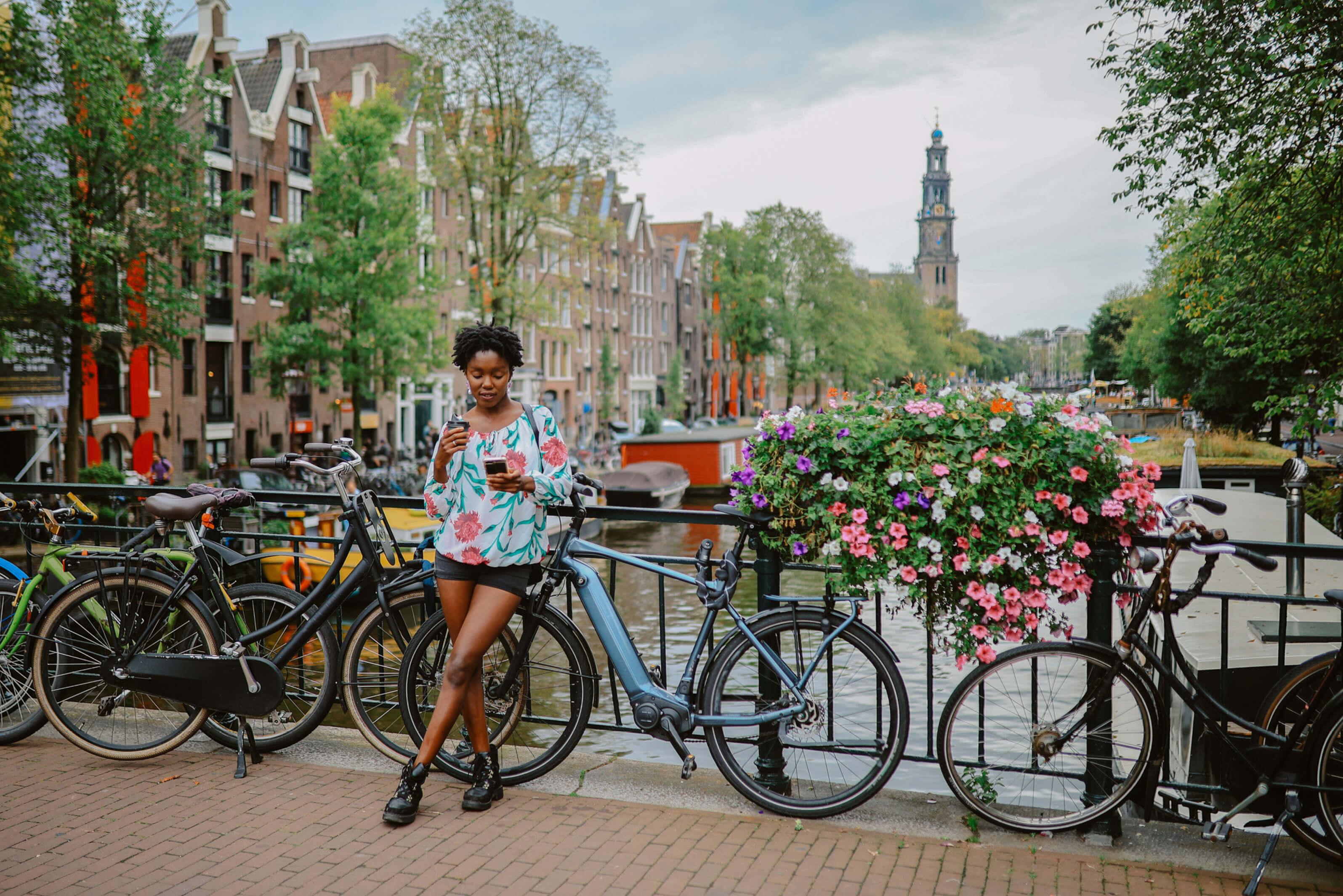 Person leaning on bike above canal in Amsterdam