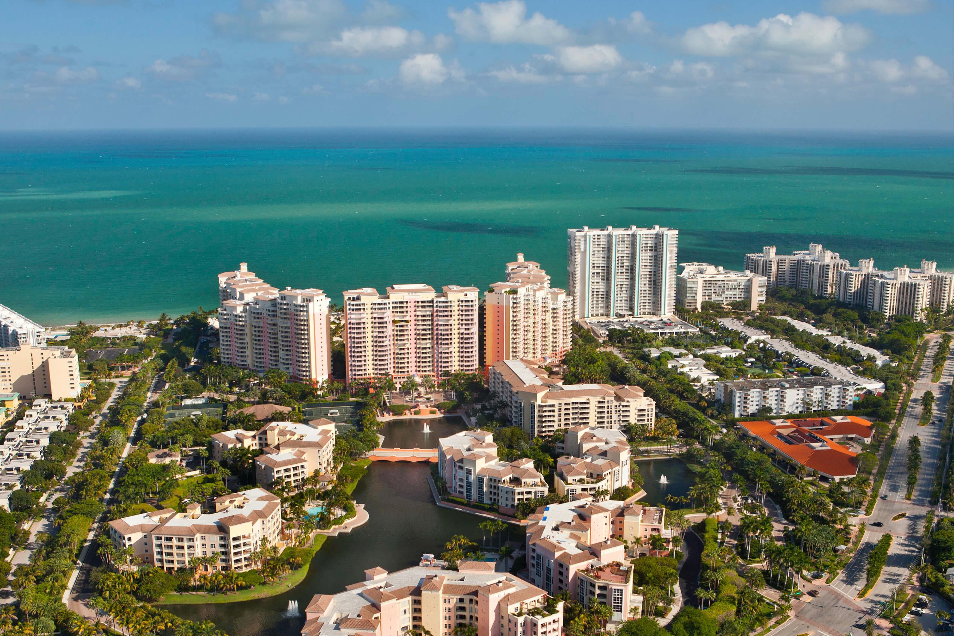 A vast expanse of water under a blue sky with high rises in foreground in Florida