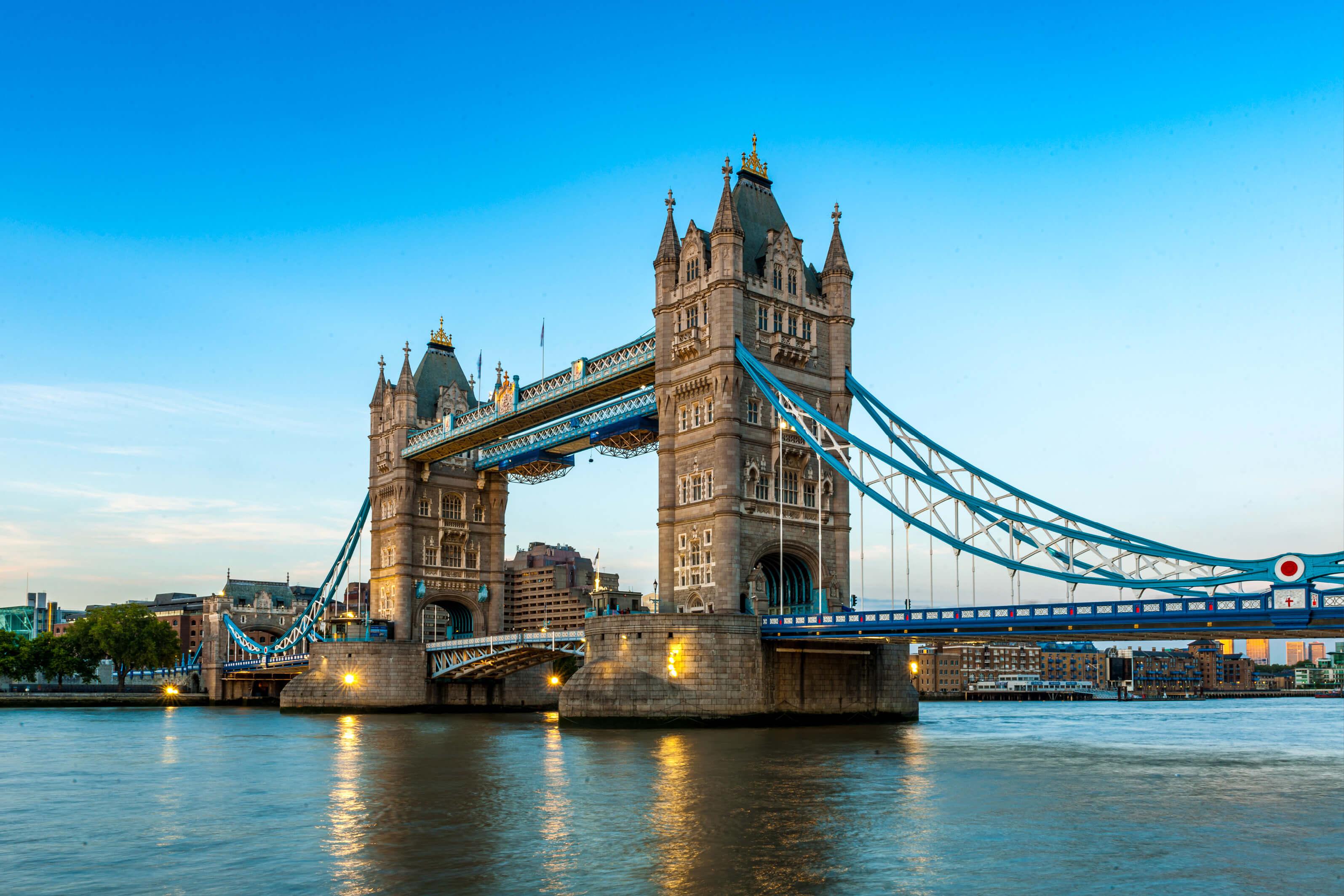 Tower Bridge in London, England, showcasing its iconic twin towers and suspension design against a clear blue sky