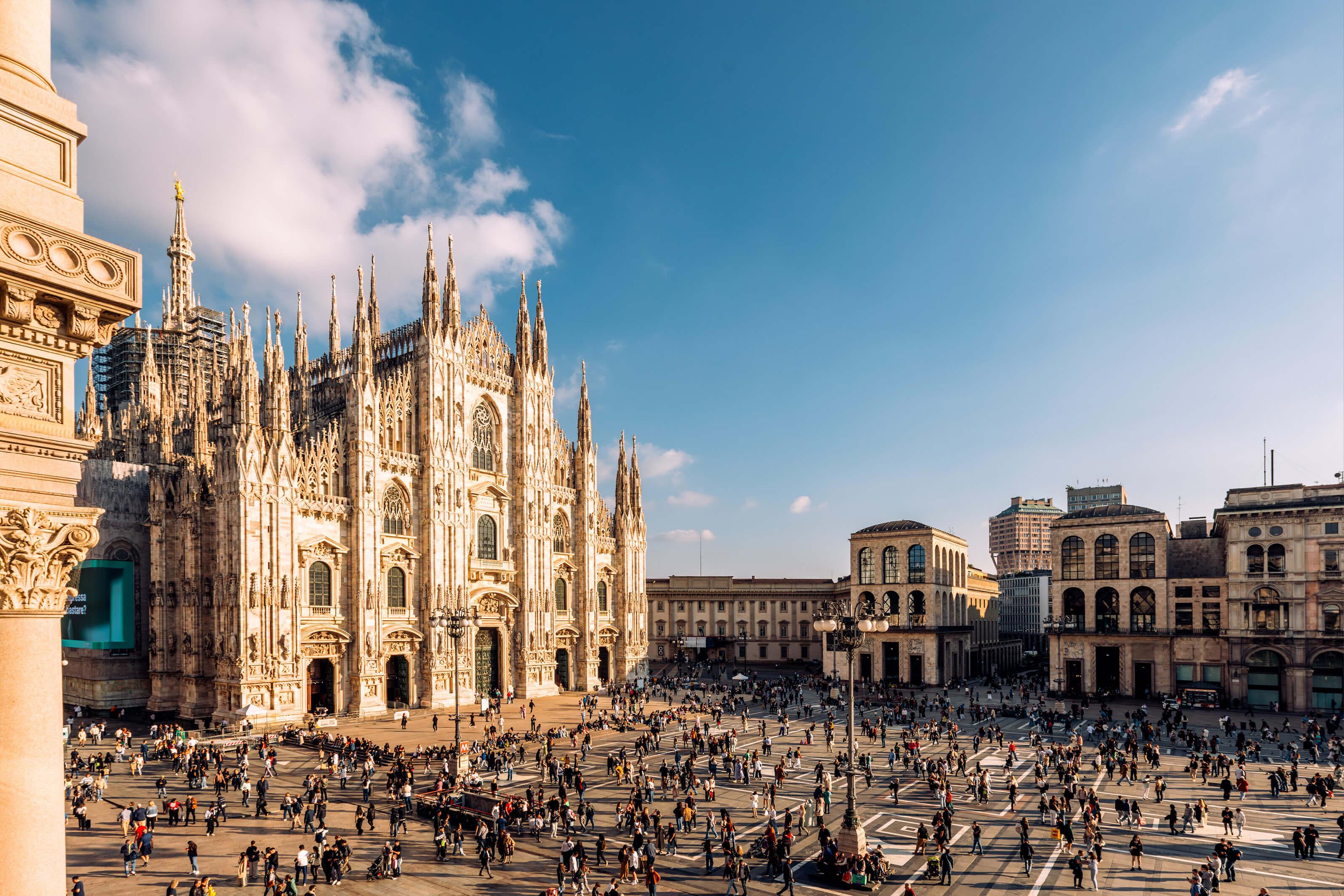 The Duomo in Milan, Italy, showcasing its intricate Gothic architecture and stunning facade under a clear blue sky