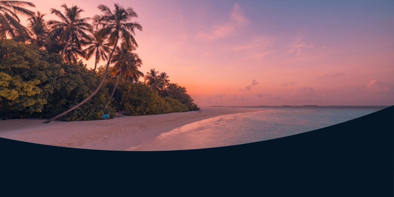 Sunset over tropical beach with palm trees and calm ocean waves