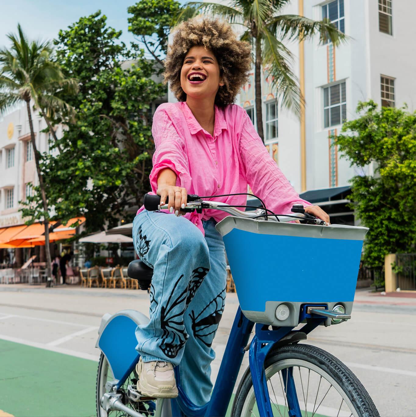 A woman joyfully rides a city bike with a basket