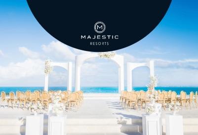 Beachfront wedding ceremony setup with white arches and seating featuring Majestic Resorts.