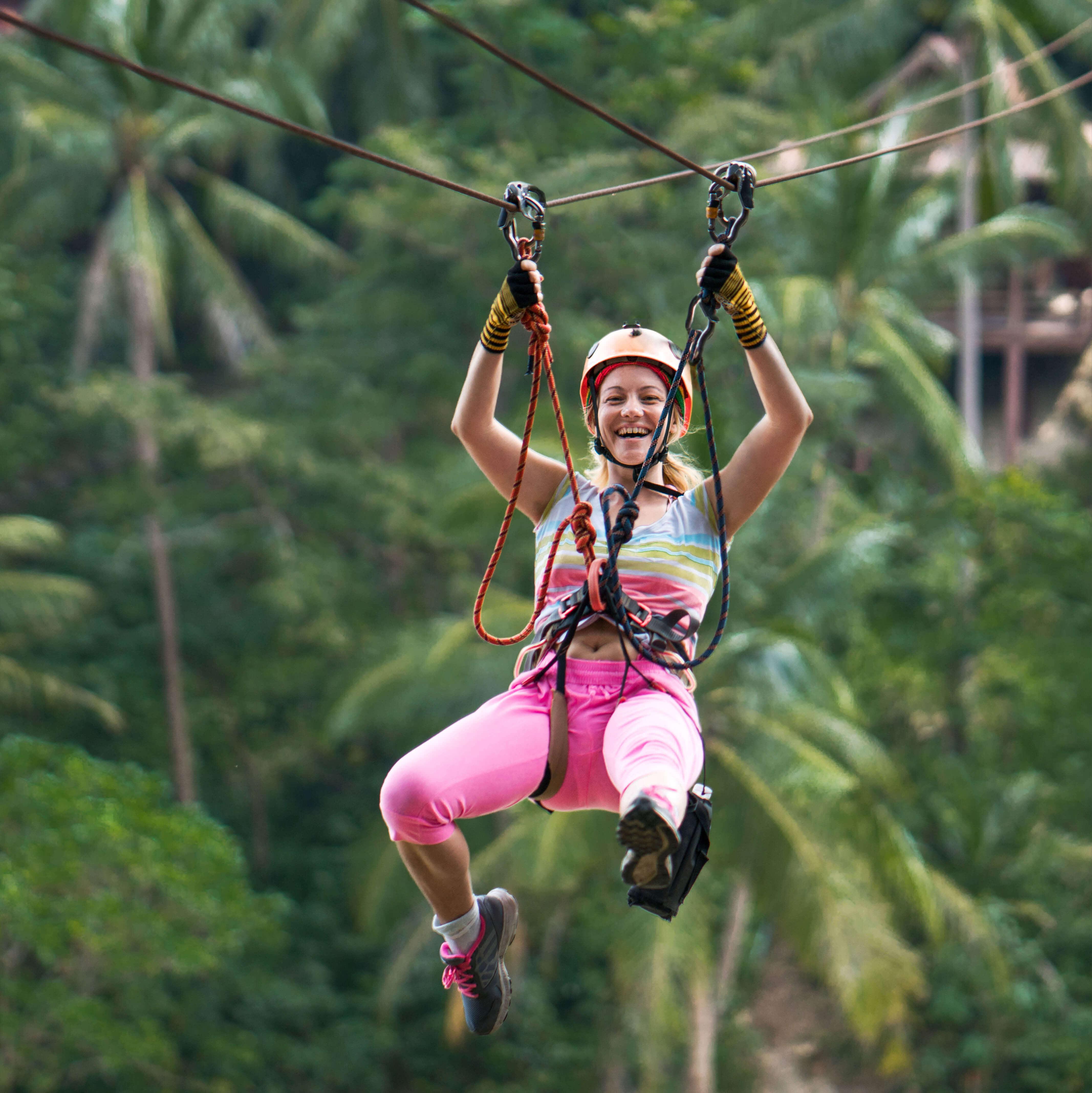 A woman looks excited while on a zipline