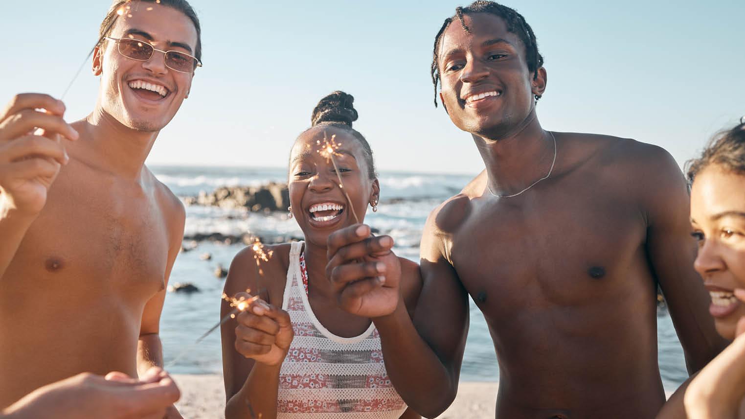 Family members smile together with sparklers on their celebratory vacation