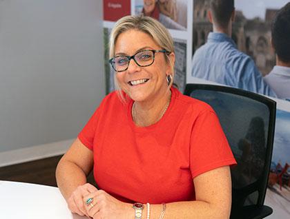 A travel advisor smiles while at her desk