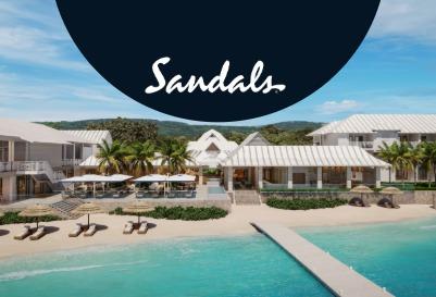 Beachfront view of a Sandals all-inclusive resort with lounge chairs, turquoise water and the Sandals logo.