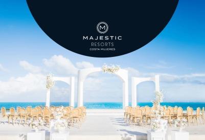 Majestic Resorts beachfront wedding venue with a white ceremony arch, rows of chairs, and ocean views under a blue sky.