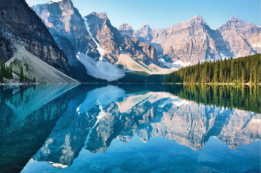 Canadian Rockies mountain lake with crystal-clear reflections and pine forest.