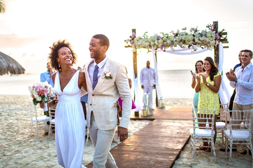 Beach wedding ceremony in Aruba with couple walking down aisle at sunset
