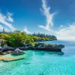 See-through water along a rugged, lush coast in the South Pacific
